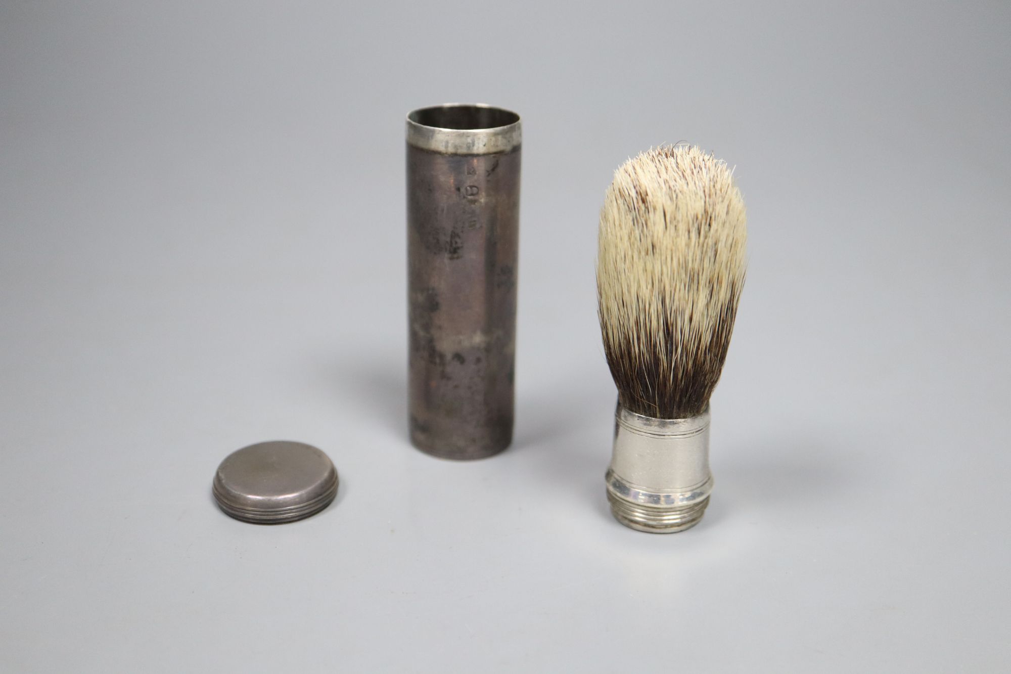 A George IV silver cased cylindrical travelling shaving brush, makers mark rubbed, London, 1824, 74mm.